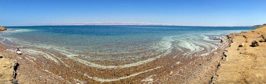 Jordanien | Panorama auf das Tote Meer bei blauem Himmel. Salzablagerungen am Rand des Wassers. Ausführliche Tipps zum Baden in unserem Artikel