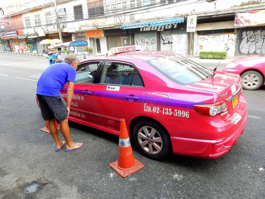 Henning verhandelt mit dem Fahrer eines der pinken Taxis von Bangkok