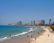 Tel Aviv | Belebter Stadtstrand von Tel Aviv mit einbrechenden Wellen vom Meer und einem Panoramablick auf die Hochhäuser des modernen Tel Aviv