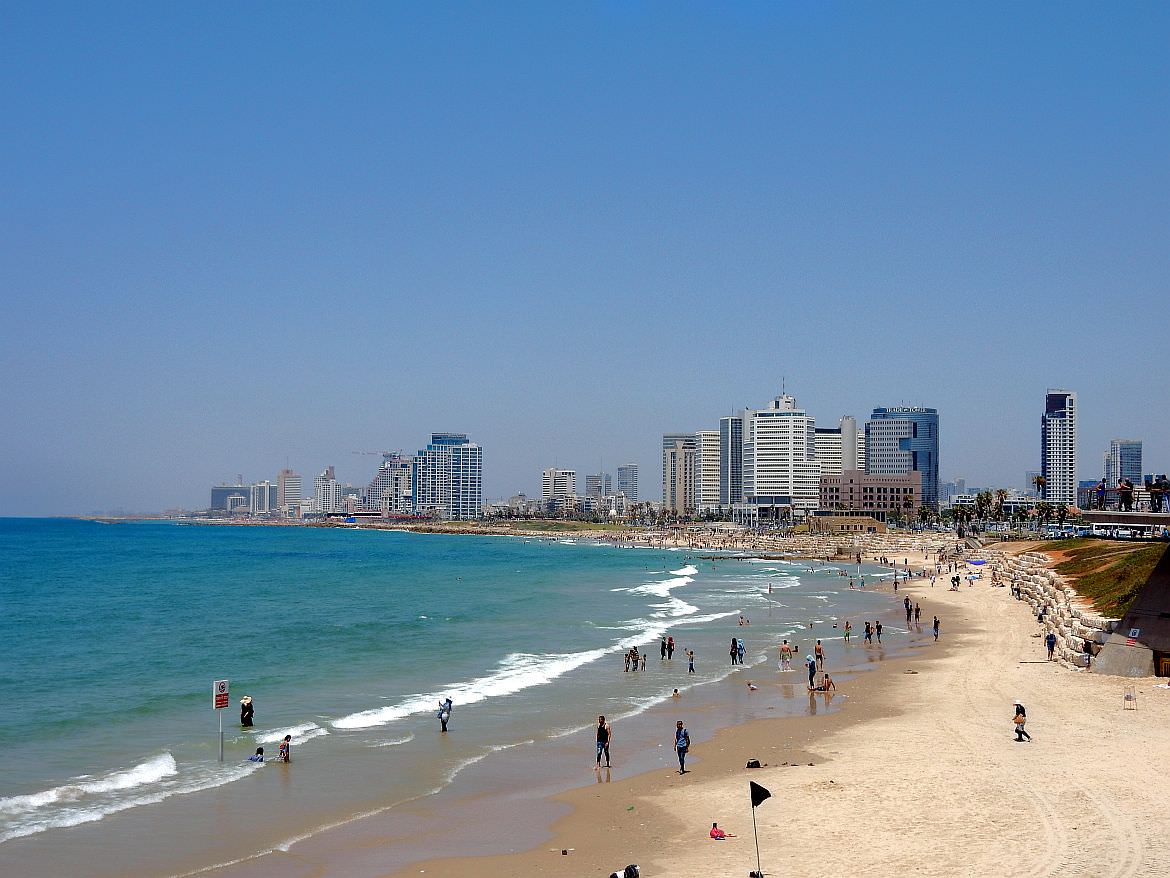 Tel Aviv | Belebter Stadtstrand von Tel Aviv mit einbrechenden Wellen vom Meer und einem Panoramablick auf die Hochhäuser des modernen Tel Aviv