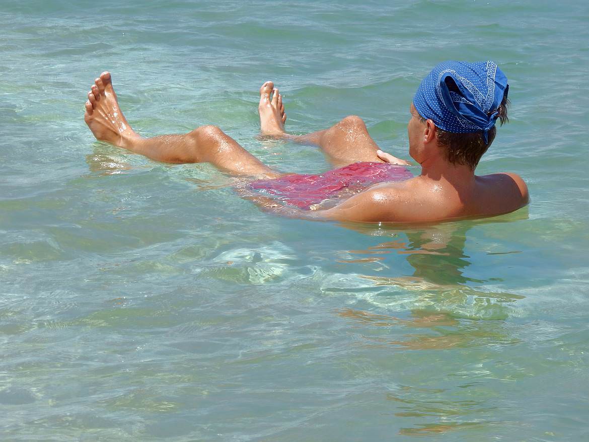 Totes Meer | Totes Meer | Baden im Toten Meer ist ein einmaliges Erlebnis. Henning liegt im Meer mit Kopfbedeckung gegen die Sonne