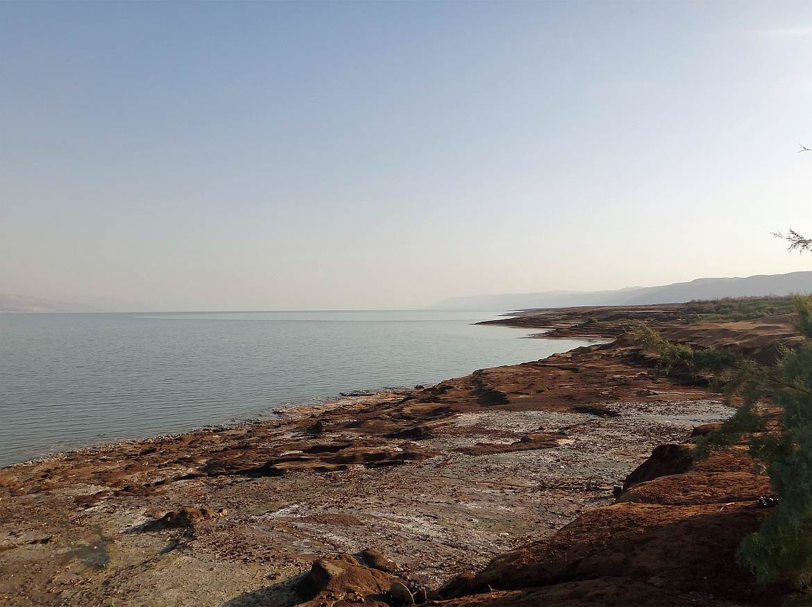 Totes Meer | Steinig brauner Strand mit Blick über das Wasser auf den Horizont