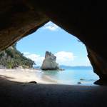 Neuseeland | Nordinsel, Cathedral Cove in der Coromandel. Blick durch die Höhle auf das türkisfarbene Meer und die Kaarststeine auf der anderen Seite. Eine der Top-Sehenswürdigkeiten & Highlights der Camping-Tour