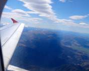 Neuseeland | Südinsel, Landeanflug Christchurch die Erste. Blick aus dem Fenster des Fliegers auf den Flügel, blauen Himmel und die schneebedeckten Alpen. Einige Tipps und den Reisebericht zur Rundreise haben wir zusammen gefasst