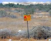 Palästina | Gelbes Schild warnt vor einem abgezäunten Minenfeld