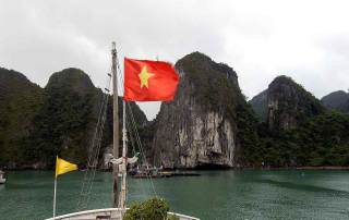 Vietnam | Norden, Panorama vom Boot unserer Ha Long Bay Cruise. Die vietnamesische Fahne am Masten, Karstberge im Hintergrund