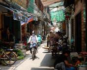 Vietnam | Norden, die Altstadt von Hanoi, die wohl in jedem Vietnam-Reisebericht unter Tipps bei Sehenswürdigkeiten erwähnt wird. EIne kleine Gasse mit verschiedenen Verkäufern und einer Frau auf dem Fahrrad