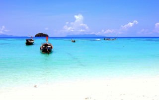 Thailand | Sunrise Beach auf Ko Lipe. Türkisfarbenes Wasser, weißer Sandstrand, blauer Himmel, ein paar Boote im Wasser