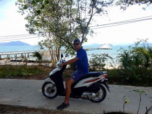 Thailand | Ao Hin Kao Bucht auf der Ostküste nicht weit vom Pier. Henning auf dem Moped vor türkisblauem Meer