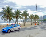 Rio de Janeiro | Sicherheit: blau-weißer Polizeiwagen vor den Palmen der Copacabana