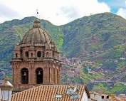 Peru | Kathedrale von Cusco am Plaza de Armas mit Blick auf sattgrüne Berge die die Stadt umgeben