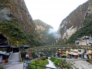 Peru | Machu Picchu, Aguas Calientes. BLick auf den Fluss und den Ortskern mit einigen Shops, Restaurants und Hotels eingebettet von Bergen