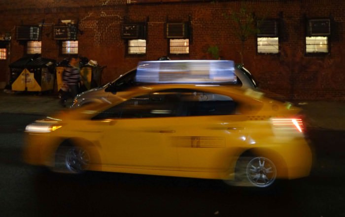 Tipps wie Du weltweit sicher und guenstig ein Taxi findest. Hier ein gelbes Taxi in einer Großstadt von Motion Blur