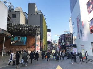 Südkorea | Seoul-Guide: Myeongdong Shopping-Straße. Blick auf Menschen und Läden mit bunten Plakaten