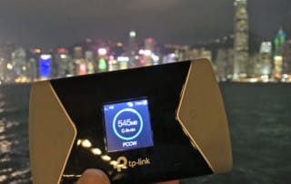 Test TP-Link M7650 | Bild des WiFi-Router vor der Skyline Hongkongs