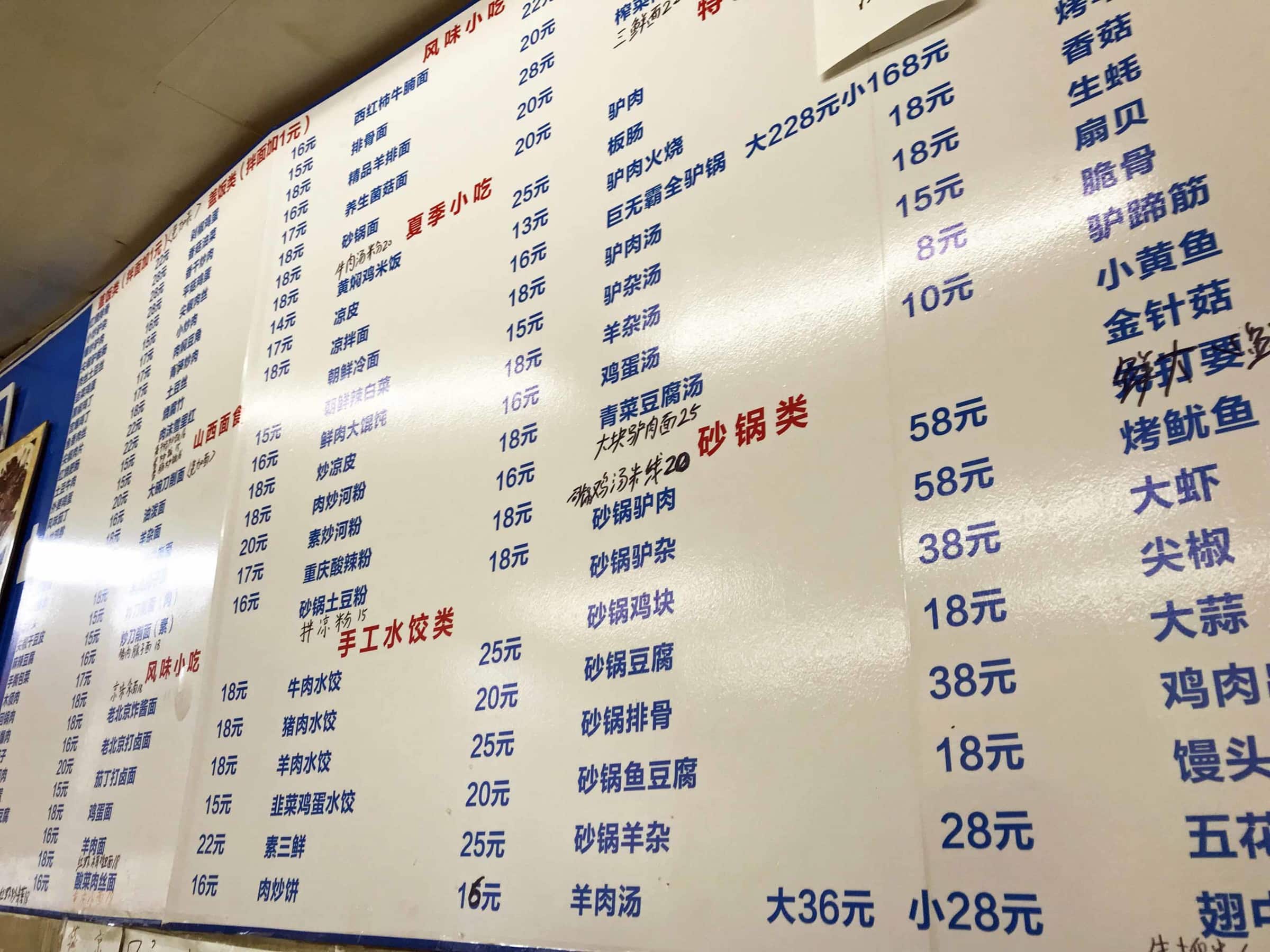 Chinesische Speisekarte in einem einfachen Restaurant in Peking. Schriftzeichen auf einer Tafel an der Wand
