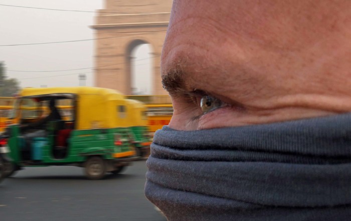 Person mit Schutzmaske vor Luftverschmutzung vor dem India Gate in Neu-Delhi